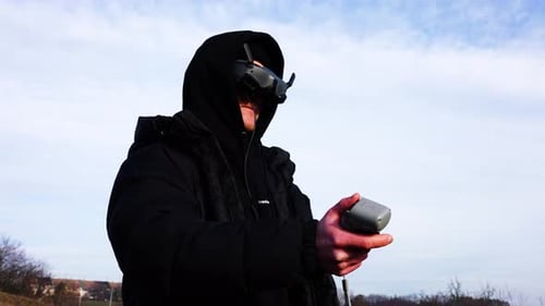 Man wear fpv drone goggles and maneuver aircraft with radio control remote