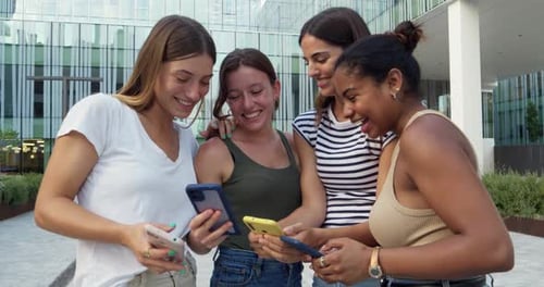 Group of Teenagers Women in a City Laughing Having a Good Time While Looking at the Smartphone