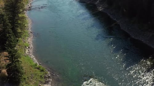 Aerial drone shot of Snake River in Alpine, Wyoming. Birds eye view of clear blue water and rocky ri