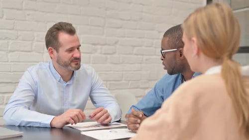 Professionals Discussing Charts During Business Meeting