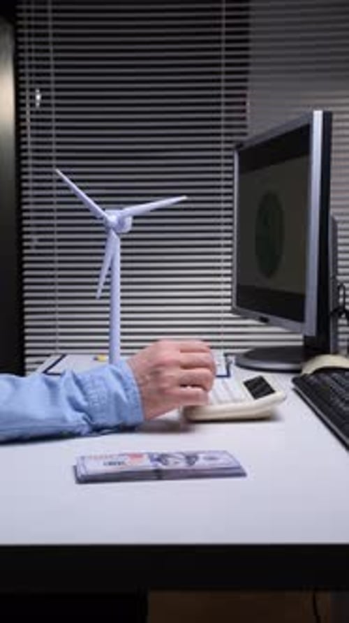 Vertical Video Person Calculating the Costs of Renewable Energy Using a Calculator with a Wind
