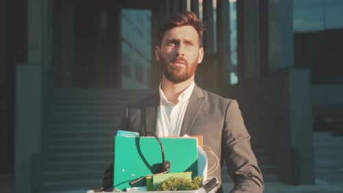 L'exécutif quitte la scène avec des documents essentiels Une personne avec une plante et des dossiers se dirige vers