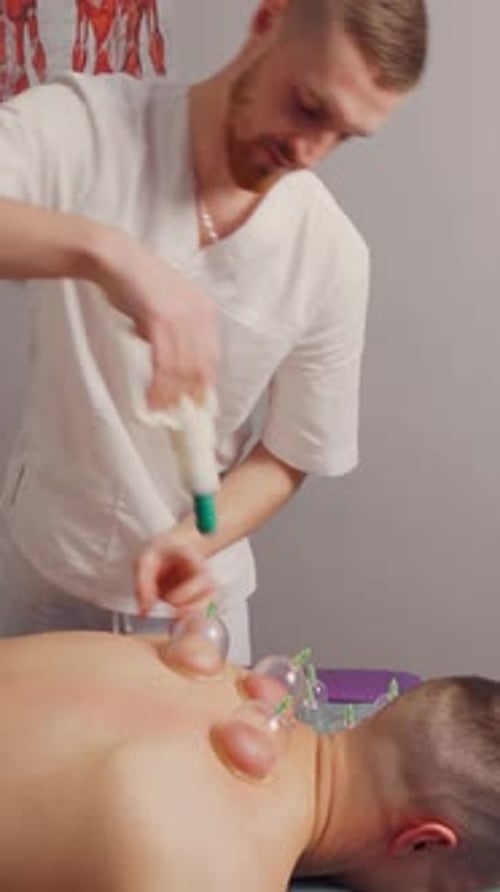 Male Therapist Cupping Treatment on Patient's Back