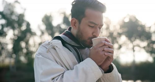 Morning, freedom and a camping man drinking coffee outdoor in nature while in the forest for travel