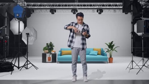 Asian Photographer Changing Lens Of Camera Before Using It Taking Pictures In The Studio