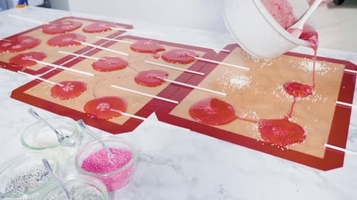 Pouring Caramelized Sugar on Silicone Mats to Make Homemade Lollipops