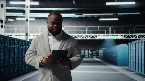 Smiling Data Center Technician Installing Server Racks Systems Using Tablet