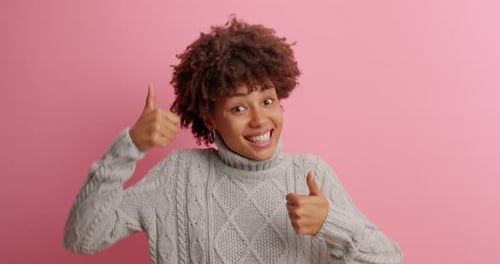 Happy Woman Gives Thumbs Up on Pink Background