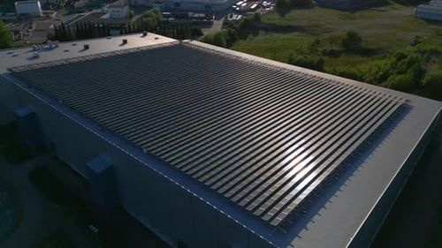 Sun reflecting off a large array of solar panels on top of a building