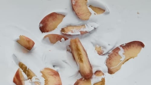 Ripe Peach Pieces Lying on White Creamy Yogurt in Super
