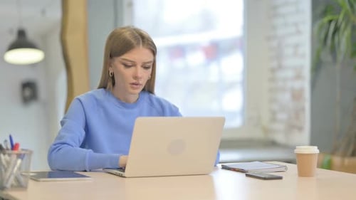 Woman Coughing While Working on Laptop in Office