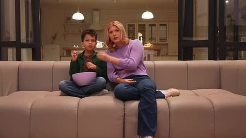 Boy and Woman Reacting to Movie While Eating Popcorn