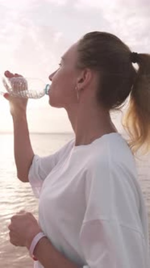 Quench Thirst After Morning Run or Workout on Seashore Woman Drinking Water Slender Young Adult Lady