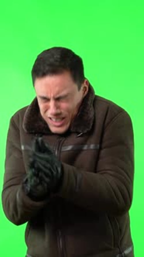 Man Shivering in Jacket Against Green Screen