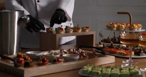 Chef arranging appetizers for buffet at table, closeup