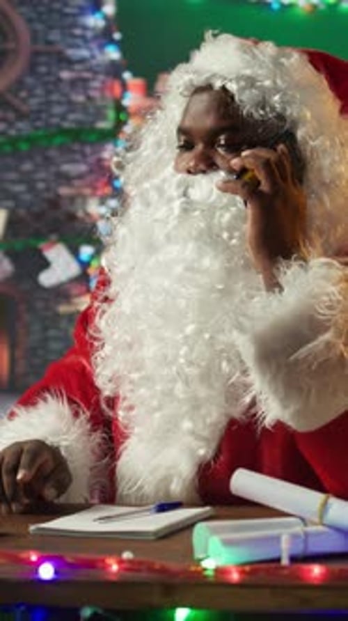 Vertical Video Black Santa Answering a Phone Call in His North Pole Workshop