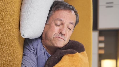Man Resting Under Blanket on Couch