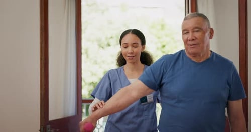 Senior Man Assisted with Arm Exercises by Healthcare Worker
