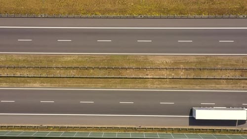 Traffic of cars and trucks on the Freeway in Summer day - top view shot. Top View shot of multi-lan