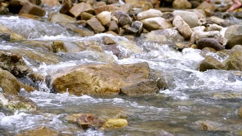 Clear stream running through stone boulders Abundant river flowing in slow motion. Wild mountain riv