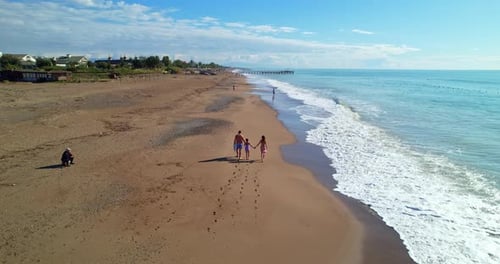 Happy Family Walking on the Beach