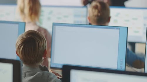 Grundschulklasse: Der Lehrer verwendet ein interaktives digitales Whiteboard und erklärt den Unterricht für verschiedene Schüler