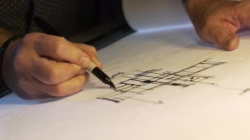Architect Engineer Sketching Blueprint on Paper in Studio Office. (4K UHD)