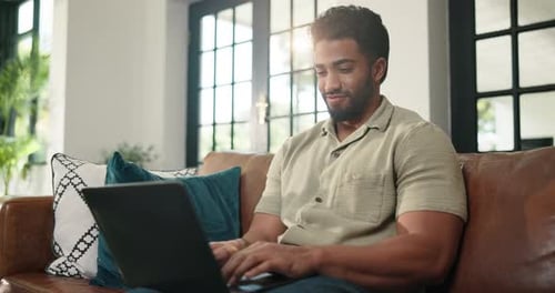 Man Using Laptop on Brown Leather Sofa Indoors