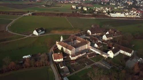 Wide aerial drone shot orbiting around Fahr Monastery in Unterengstringen, Switzerland