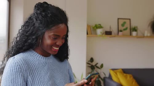 Woman Using Smartphone in Modern Apartment