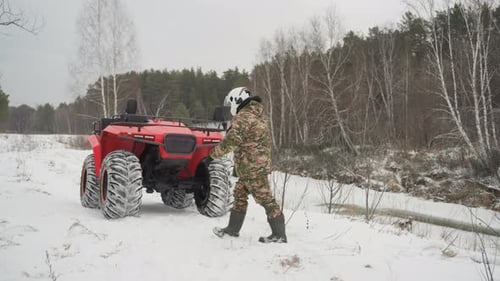 Hidden Motorcyclist Gets Ready Amid Snow and Trees Disguised Rider Assesses Vehicle in Winter