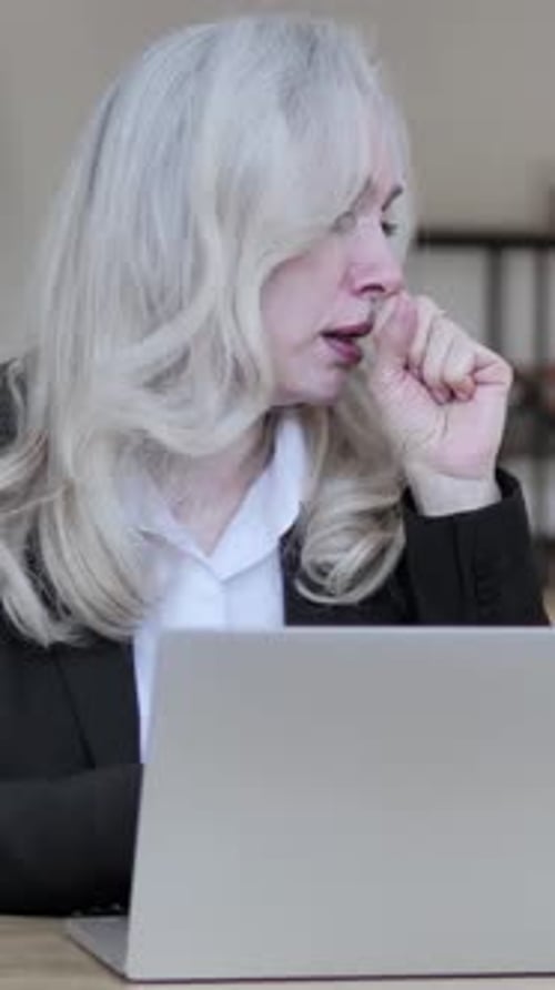Woman Working at Laptop Couging While at Desk