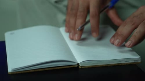Hand Writing in Blank Book on Table Close Up