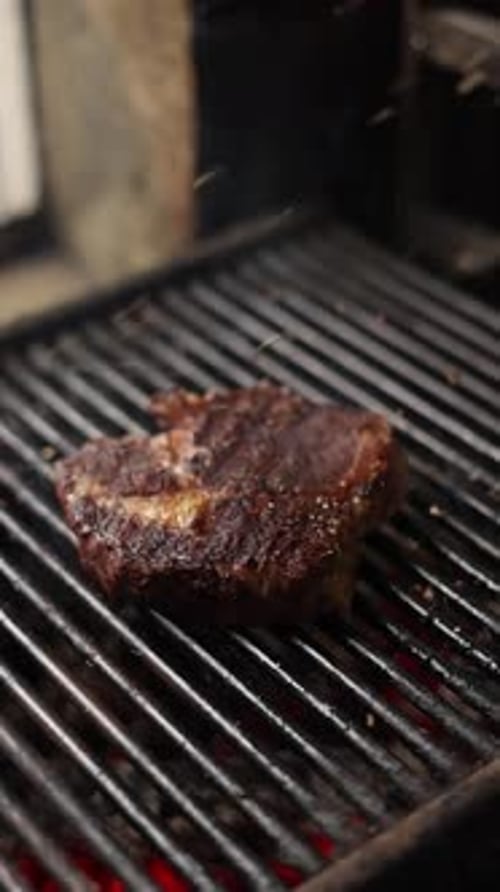 the chef prepares delicious steak dishes in the restaurant. the grill