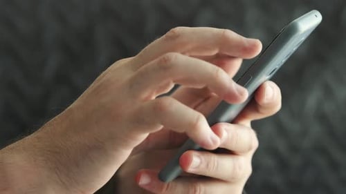 Close-up of Hand Using Modern Mobile Phone