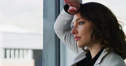 Woman Looking Thoughtfully out Window, Close Up