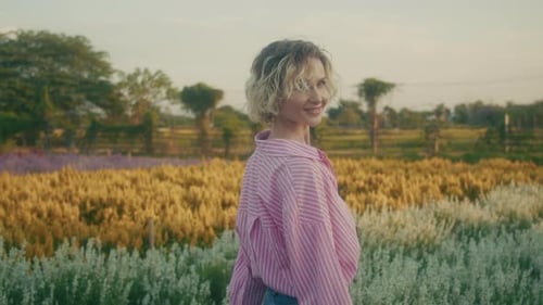 A Serene Woman Posing Gracefully in a Beautiful Colorful Flower Field During Sunset Hours