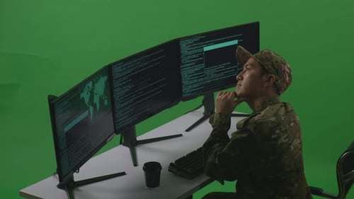 Side View Of Asian Man Soldier Thinking While Write Code With Multiple Screens In Green Screen