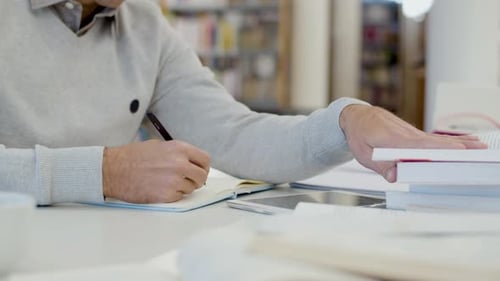 Close Up of Person Writing in a Library