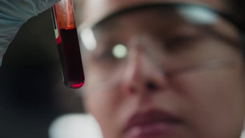Close-Up of Lab Scientist Examining Blood in Test Tube