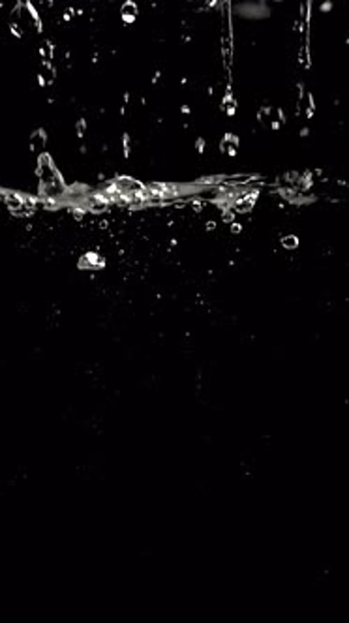 Water Droplets Falling in Slow Motion on Black Background