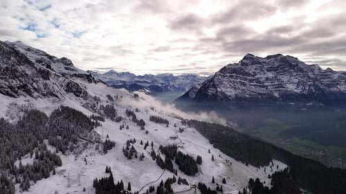 Winter nature valley mountains alpine snow covered landscape, drone aerial view Switzerland