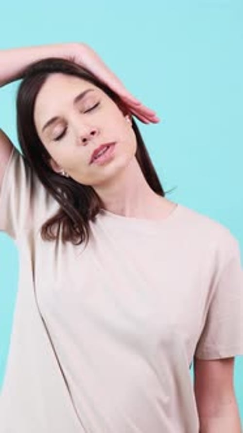 Woman Doing Neck Stretches on Blue Background