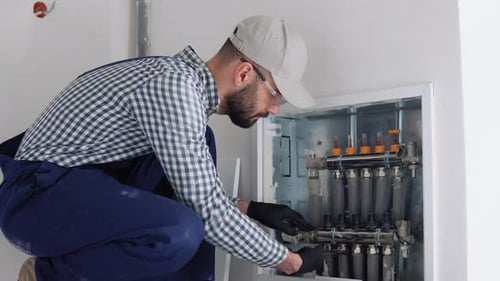 Heating Engineer Installing Modern Heating System in Boiler Room