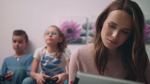 Woman and Children Play Video Games at Home