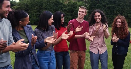 Young diverse people clapping hands outdoor