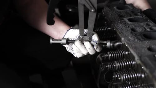 Mechanic Working on Engine with Tool Close Up