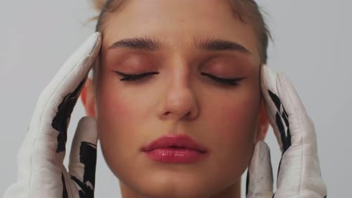 Woman's Face Framed by Gloved Hands, Close-up