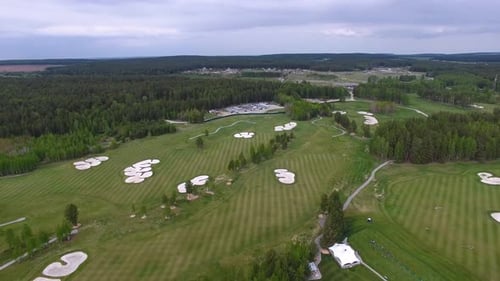 A Stunning Aerial View Captured of a Beautifully Lush Golf Course Enveloped By Tall Forest