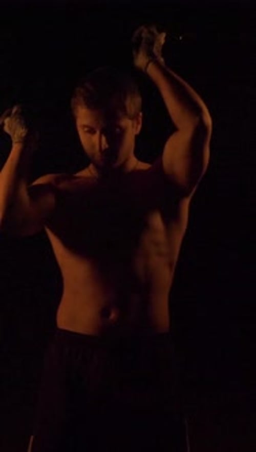 Shirtless Man Spins Fiery Poi in the Dark